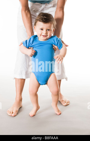 Madre insegnamento baby boy come andare a piedi Foto Stock