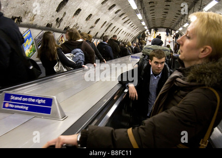 Pendolari sulla metropolitana di Londra scale mobili durante le ore di punta Foto Stock