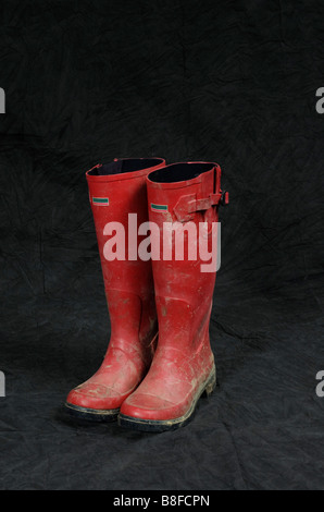 Wellingtons sporca in uno sfondo per studio Foto Stock