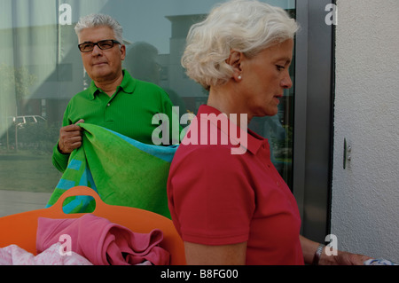 Coppia senior di stendere la biancheria Foto Stock