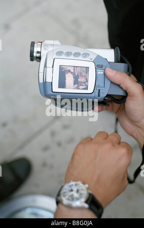 Uomo con una fotocamera digitale che mostra una foto di un matrimonio - Tecnologia Foto Stock