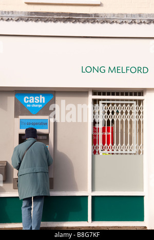 Una donna tramite bancomat speedbank macchina fuori la Co-op foodstore shop store in Long Melford,Suffolk, Regno Unito Foto Stock