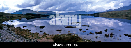 Una vista panoramica del cielo nuvoloso oltre la pacifica acqua del Loch Tulla su Rannock Moor Foto Stock