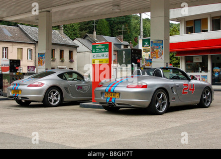 Porsche Cayman (987) e Boxster S (550 Spyder) con Martini racing strisce in un villaggio francese stazione di benzina. Foto Stock