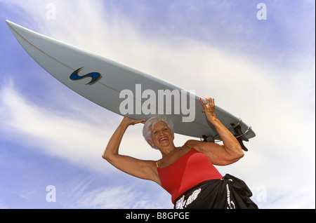 Senior donna, andando surf, Miami Foto Stock