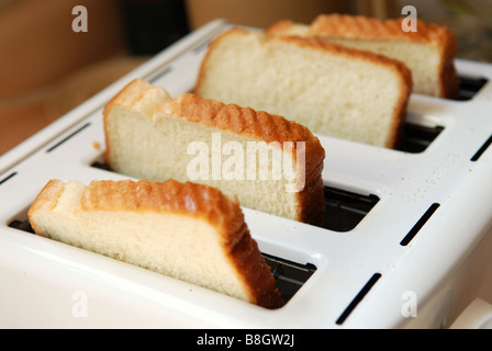 Un grande Tostapane bianco con quattro fette di pane bianco Foto Stock