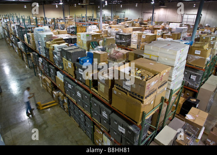 Magazzino pieno di inventario visto dal di sopra con il lavoratore utilizzando un carrello elevatore. Foto Stock