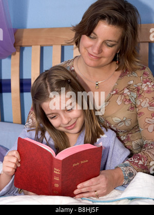 Madre e figlia di leggere la Bibbia insieme a letto vista verticale Foto Stock