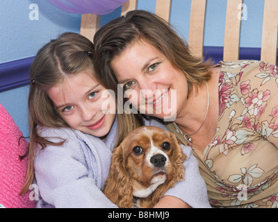 Una madre e figlia in posa con loro cavalier spaniel cane Foto Stock