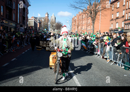 Un partecipante onde per la folla di il giorno di San Patrizio parata in Dublino Irlanda Foto Stock