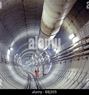 Ingegnere di ispezionare una sezione di recentemente scavato e segmentati in calcestruzzo Jubilee Line tunnel ferroviario di Londra sul tubo della rete. Foto Stock