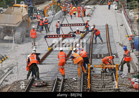 Appaltatori rampa abbassa una sezione di elementi prefabbricati di via con rotaie e traversine installati sul collegamento ferroviario del tunnel della Manica. Foto Stock