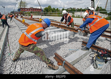 Appaltatori rampa abbassa una sezione di elementi prefabbricati di via con rotaie e traversine installati sul collegamento ferroviario del tunnel della Manica. Foto Stock