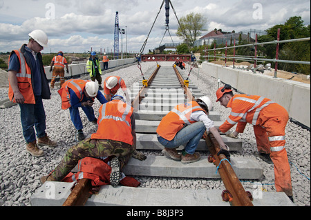 Appaltatori rampa abbassa una sezione di elementi prefabbricati di via con rotaie e traversine installati sul collegamento ferroviario del tunnel della Manica. Foto Stock