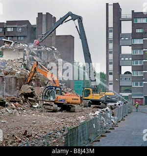 Montato sulla macchina del demolitore distruggendo i muri in cemento armato di blocco residenziale durante lavori di demolizione per il rinnovamento urbano progetto Foto Stock