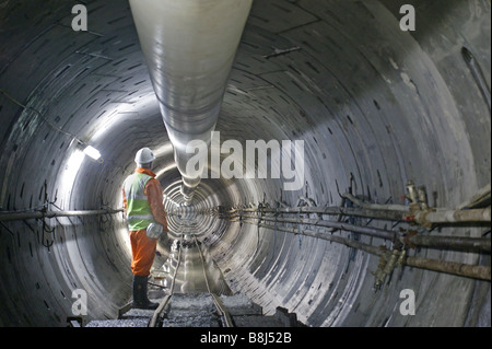 Ingegnere ispeziona una sezione completa di cavo di alimentazione in tunnel di Londra, scavate dalla macchina di foratura di gallerie. Foto Stock