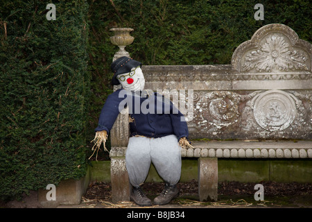 Crollati, seduto su una panchina di pietra Spaventapasseri Festival, evento Tatton giardini, Tatton Park, Cheshire Foto Stock