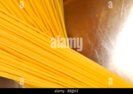 Spaghetti secchi nel piatto di pesata in acciaio inox non cotti acqua grezza cibo italiano carboidrati bolognese arnese da cucina per la cottura white bac Foto Stock