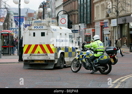 PSNI polizia moto uomo e blindato di land rover riot veicolo vicino fuori strada per il giorno di San Patrizio parade Belfast Northern Irelan Foto Stock