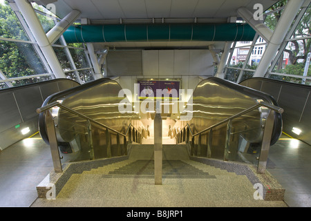 Esclators il collegamento alla metropolitana MRT in Singapore Foto Stock