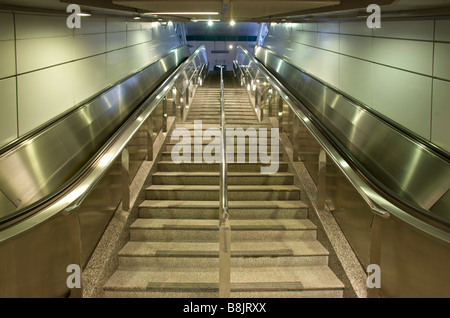 Esclators il collegamento alla metropolitana MRT in Singapore Foto Stock