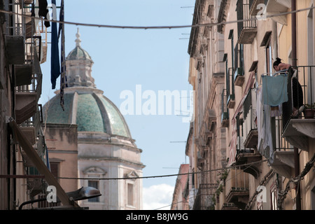 Una donna rimane in sospeso il lavaggio in una strada che si affaccia sulla Cattedrale di San Lorenzo,Trapani, Sicilia Occidentale, Italia Foto Stock