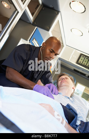 Paramedic frequentando il paziente in ambulanza Foto Stock