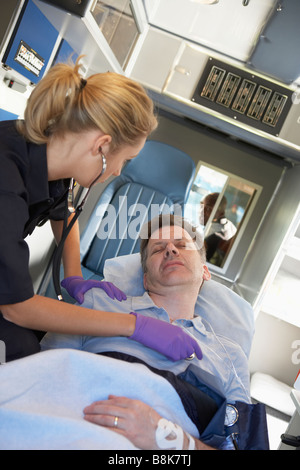 Paramedic frequentando il paziente in ambulanza Foto Stock