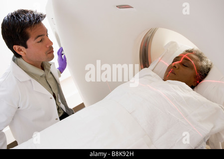 Medico con il paziente avente una Tomografia Assiale Computerizzata (CAT) scansione Foto Stock