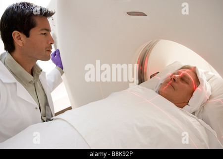 Medico con il paziente avente una Tomografia Assiale Computerizzata (CAT) scansione Foto Stock