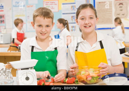 Maschio e femmina studente preparare frutta tagliata Foto Stock