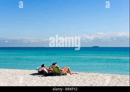 Due uomini a prendere il sole sulla spiaggia di South Beach a Miami Beach, Gold Coast, Florida, Stati Uniti d'America Foto Stock
