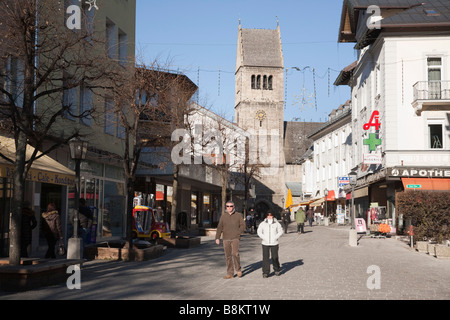 Zell am See Austria vista lungo la zona pedonale High Street nel centro commerciale del centro di San Ippolito Chiesa parrocchiale di clock tower Foto Stock