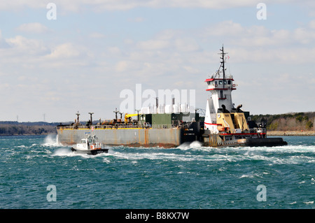 Rimorchiatore da KSea spingendo a doppio scafo di olio combustibile barge attraverso "Cape Cod Canal' con un 'Pilota di Barca in acqua instabile. Foto Stock