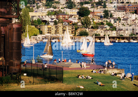 Stati Uniti d'America, nello Stato di Washington, Seattle. Barche a vela sul lago di unione di rusty passa per la conversione di gas reliquie a lavori Gas Park. Foto Stock