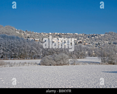 Prati di bianco con un sacco di neve nel villaggio di sfondo Eckartsborn un quartiere della città Ortenberg Foto Stock