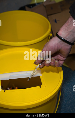 La caduta di mano di uso di droghe in aghi sharps bin Foto Stock