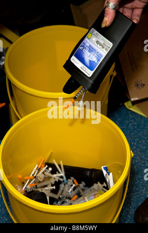 La caduta di mano farmaci ago in bottiglia sharps bin Foto Stock