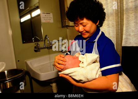 Whipps Cross Hospital di Londra 1988 Un infermiere tiene un neonato Foto Stock