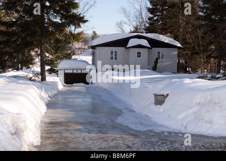 Cottage di campagna da un lago in inverno con gelido carraio Foto Stock