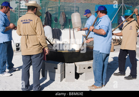 Torrox Pueblo regione Axarquia Malaga Spagna Migas Festival uomini preparare le migas in una grande padella a fuoco di legno Foto Stock