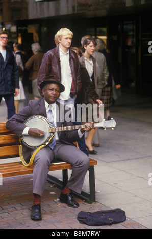 Windrush Generation un uomo anziano britannico di colore che cammina nel centro di Manchester. Inghilterra circa 1985 1980s Regno Unito HOMER SYKES Foto Stock