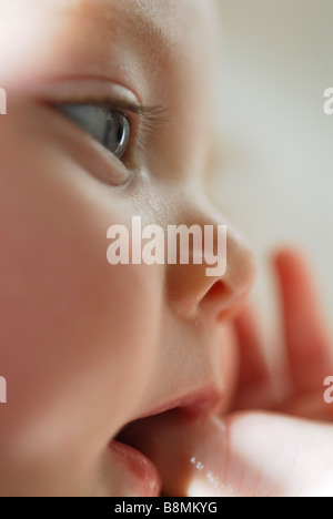 Close up ritratto di bambino di 4 mesi ragazza succhiare il pollice Foto Stock