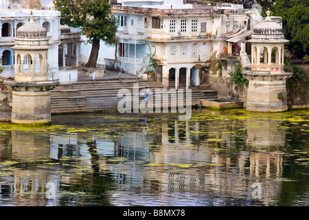 Uomo indiano la balneazione e lavare i loro vestiti Lago Pichola Udaipur Rajasthan in India Foto Stock