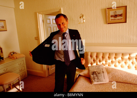 Jeffrey Archer autore ed ex deputato del partito conservatore si toglie la sua giacca avente appena arrivati ad un golf hotel Foto Stock