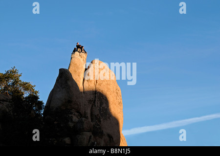 Tre arrampicatori l uomo e la donna sempre pronto a scendere dalla parte superiore di un pinnacolo di roccia Hidden Valley Joshua Tree National Park Foto Stock