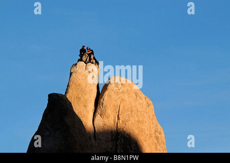 Due arrampicatori l uomo e la donna sempre pronto a scendere dalla parte superiore di un pinnacolo di roccia Hidden Valley Joshua Tree National Park Foto Stock