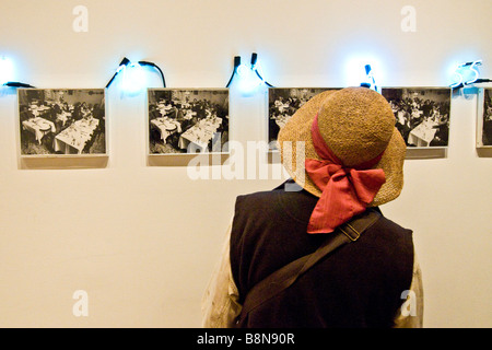 Visitatore la visualizzazione di una mostra di piccole in bianco e nero stampe fotografiche e i numeri illuminati presso il Museo di arte moderna Foto Stock