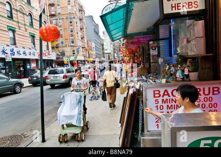 I pedoni a camminare lungo il marciapiede a Chinatown Foto Stock