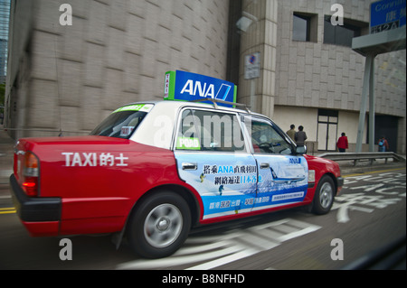 Il bianco e il rosso Toyota Crown taxi muovendosi attraverso Hong Kong di Wan Chai district Foto Stock